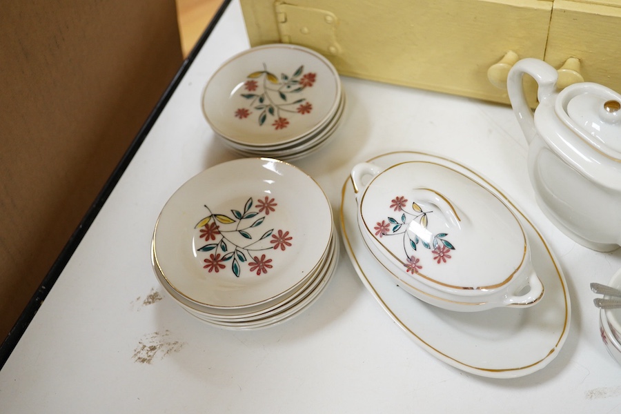 A 1930's handmade painted toy dresser with a miniature dinner service stamped ‘Foreign’ to the bases, comprising teapot, tureen, serving dish, plates, cups, etc. Condition - fair.